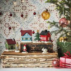 christmas decorations and ornaments are on top of an old book in front of a wallpapered background