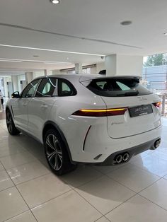 a white car is parked in a showroom