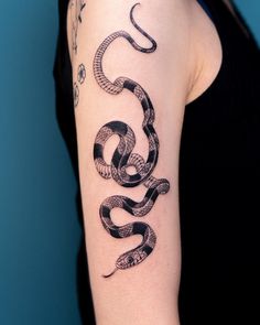 a woman with a snake tattoo on her arm