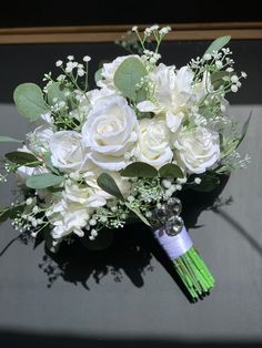 a bridal bouquet with white roses and greenery