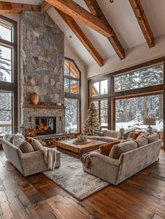 a living room filled with furniture and a fire place in front of two large windows