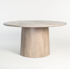 a round wooden table sitting on top of a white floor