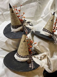 three witches hats are sitting on top of each other, with orange berries in the middle