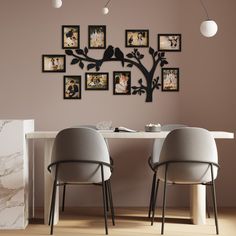 two chairs sitting at a table with pictures on the wall