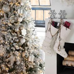 a white christmas tree with stockings hanging from it