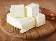 cubes of butter on a wooden cutting board with a knife