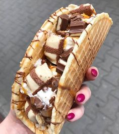 a person holding a waffle with chocolate and bananas on it