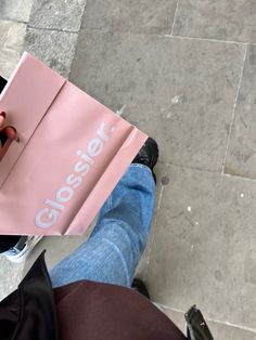 a person holding up a pink shopping bag with the word closer on it's side