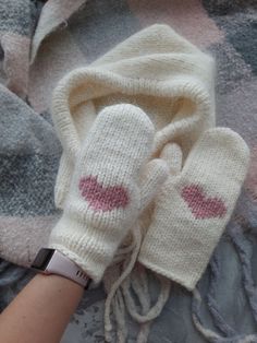 a person's hand with two mittens on top of a blanket