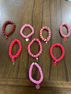 several different colored bracelets sitting on top of a wooden table