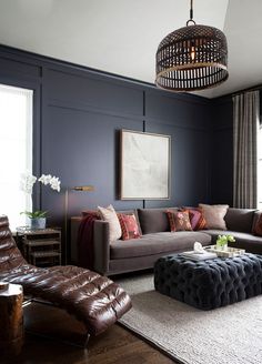 a living room filled with furniture and a chandelier hanging from the ceiling in front of a window