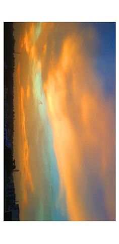 the sky is filled with clouds as it looks like an orange and yellow cloud in the distance