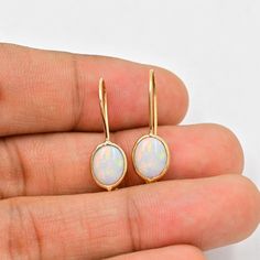 Natural Australian Opal Earrings (Pair) ✪Gemstone: Natural Australian Opal  ✪Metal: 18k solid Yellow gold. ✪Stone size: 6x8 mm. ✪Stone Shape :Oval  ✪Stone Weight : 2 Ct. ✪ Earring Weight : 1.25 Gram ✪Earring Length : 25 mm. ✪Earring width : 7 mm. ✪Setting type: Bezel wire setting. If you need any other preferred stone please contact us. Opal benefits - *The stone is believed to counteract bad effects and bring prosperity, beauty, love, and romance in like.  *It brings success in dating and benefits those who are in dairy and hospitality industry. *Opal gemstone benefits include enhancing joy in marital life.   QUALITY OF MATERIALS: Metal: Most of our jewelry at JewelryMansion is made with precious metals like gold and silver. These metals are 100% non-allergic to our skin. Gemstone: All of Yellow Gold Opal Gemstone Earrings, Opal Earrings With Ear Wire For Gift, Opal Yellow Gold Earrings For Gifts, Opal Ear Wire Earrings For Gift, Yellow Gold Opal Earrings Gift, Gold Opal Cabochon Earrings, Fine Jewelry Opal Earrings For Gift, Oval Opal Earrings In Yellow Gold, Yellow Gold Opal Earrings For Gifts