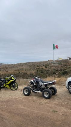 three atvs parked on the side of a dirt road next to a white car