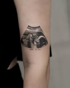 a woman's arm with a black and white tattoo on it that says hello my son