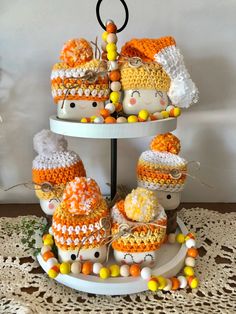 three tiered trays with hats and candy on top of each other, decorated like snowmen