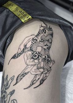 a woman's thigh with a tattoo design on it