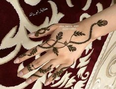 a woman's hand with henna tattoos on it