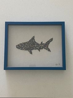 a blue frame with a picture of a shark in it's mouth on the wall