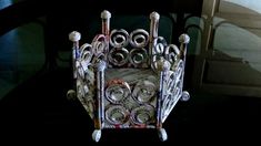 an intricately designed chair made out of newspaper rolls and other items sitting on a table