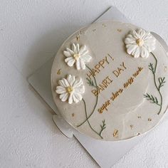 a birthday cake with white flowers on it