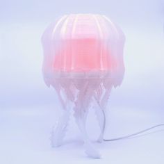 a pink jellyfish lamp on a white background with the light turned on and red