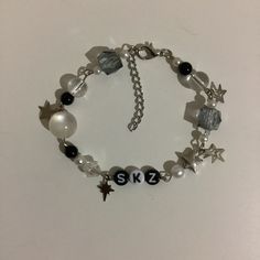 a bracelet with charms that say sk2 and have star charms on the clasps