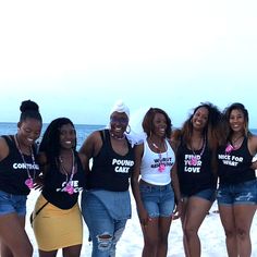 four women standing on the beach in front of the ocean wearing t - shirts that say, i don't know what they are