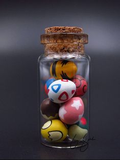 a glass jar filled with lots of different colored balls