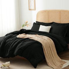 a bed with black sheets and pillows in a room