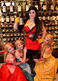 a group of women standing next to each other in front of shelves of wine bottles