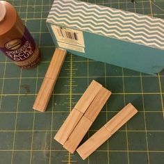 some wood sticks and glue sitting on top of a cutting board next to a box