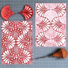 some red and white paper cut out on a gray surface with a pair of scissors