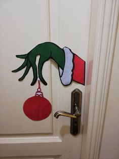 the door is decorated with an elf's hand holding a christmas ornament