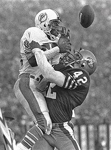 two football players are hugging each other in front of an audience and one is holding the ball