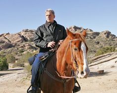 a man riding on the back of a brown horse