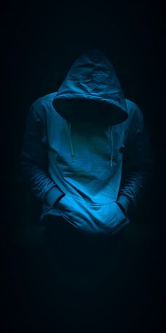 a person wearing a hoodie in the dark with their hands on their hipss