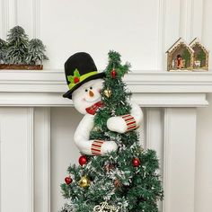 a small christmas tree with a snowman on top