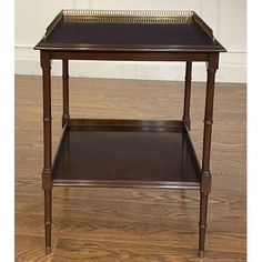 a small wooden table with a tray on it's top sitting on a hard wood floor