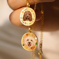 a person holding two pendants with a dog on them