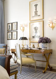 a living room filled with furniture and pictures on the wall above it's desk