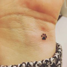 a small dog paw tattoo on the wrist