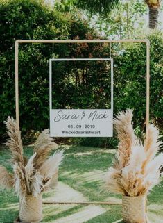 two vases with pamodia in front of a sign for the wedding ceremony