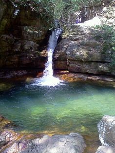 there is a waterfall in the middle of some rocks