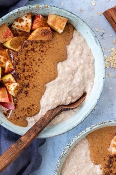 two bowls filled with oatmeal, cinnamon and apple slices next to each other