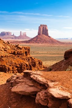 a rock formation in the desert with mountains in the background