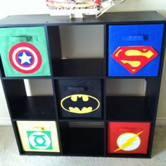 a book shelf with different colored superman and batman logos painted on it's sides