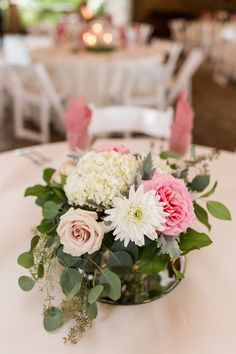 a vase filled with white and pink flowers on top of a table