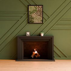 a fire place in a room with green walls and wood flooring on the side