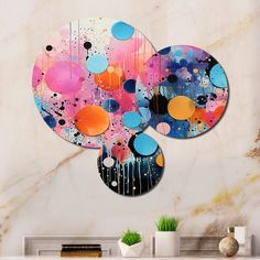 an abstract painting on the wall in a living room with two circular mirrors hanging from it's sides